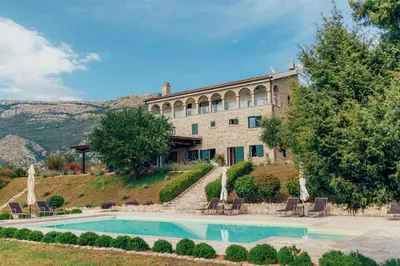 a large building with a swimming pool in front of it at MonteBay villa in Budva