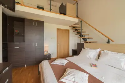 a bedroom with a large bed and a staircase at MonteBay villa in Budva