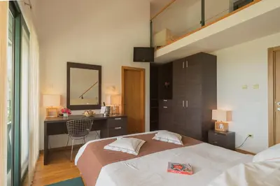 a bedroom with a bed and a desk with a mirror at MonteBay villa in Budva