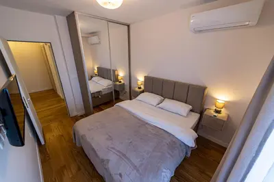 a bedroom with a large bed and a mirror at Apartments Centrale 28 in Podgorica