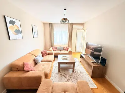 a living room with two couches and a flat screen tv at Apartments Centrale 28 in Podgorica