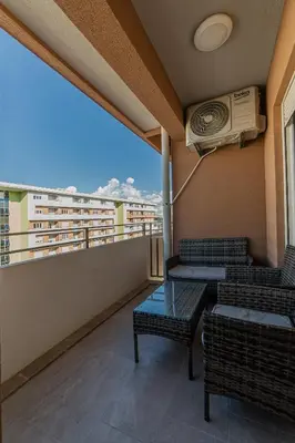 a balcony with chairs and a table and a air conditioner at Apartments Centrale 28 in Podgorica