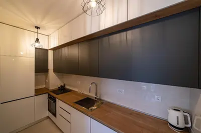 a kitchen with white cabinets and a sink at Apartments Centrale 28 in Podgorica