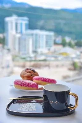 two donuts on a plate next to a cup of coffee at Adriatic Dream - Sea View Apartments in Budva