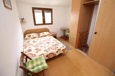a small bedroom with a bed and a window at Meric Duplex Apartment in Budva