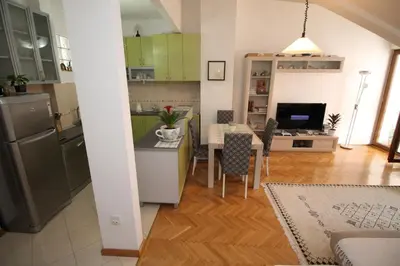 a kitchen and living room with a table and a dining room at Meric Duplex Apartment in Budva