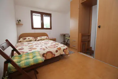 a small bedroom with a bed and a window at Meric Duplex Apartment in Budva