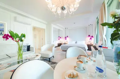 a white room with a bed and a table and chairs at Boutique Hotel Vissi d'Arte in Budva