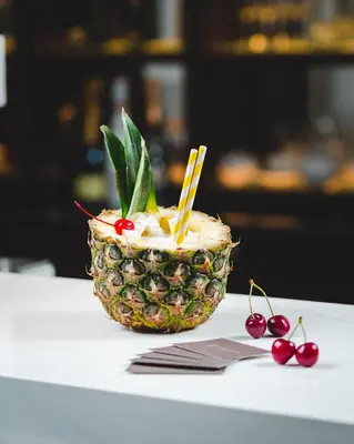a pineapple dessert on a table next to cherries at Boutique Hotel Vissi d'Arte in Budva