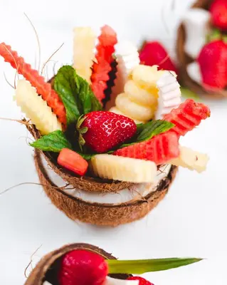 a fruit salad in a coconut bowl with strawberries at Boutique Hotel Vissi d'Arte in Budva