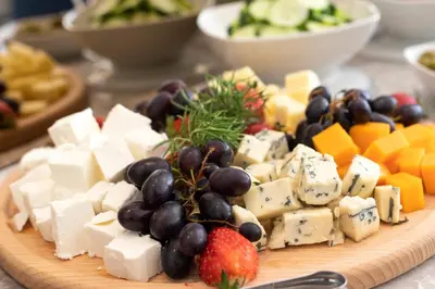 a plate of cheese and fruit on a table at Boutique Hotel Momentum by Aycon in Budva