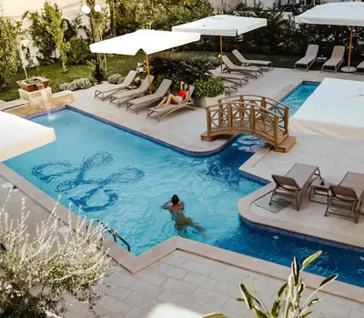 a pool with a person sitting in a chair in the water at Boutique Hotel Momentum by Aycon in Budva