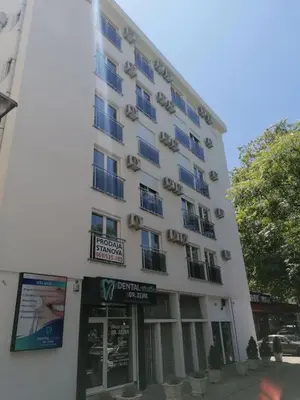 a tall white building with a sign in front of it at Anja apartment_City Center_ in Bar
