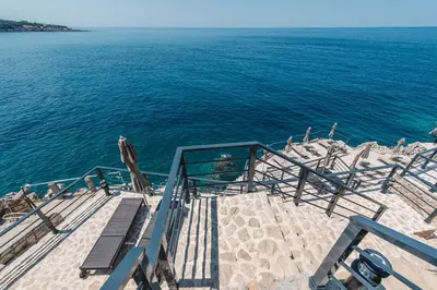 a stairway with chairs and the ocean with at Dollaku Apartments in Bar