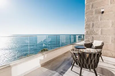 a balcony with two chairs and a view of the ocean at Dollaku Apartments in Bar