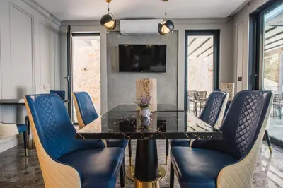 a dining room with a glass table and blue chairs at Dollaku Apartments in Bar