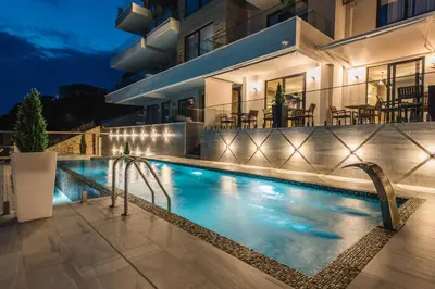a villa with a swimming pool at night at Dollaku Apartments in Bar