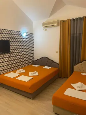 a small room with two beds and a tv at SARA BUDVA in Budva