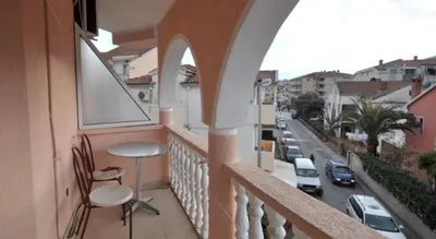 a balcony with two chairs and a view of a street at SARA BUDVA in Budva