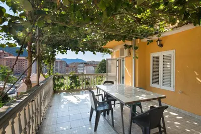 a table and chairs on the balcony of a house at Apartments Antic in Budva