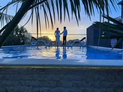 two people standing next to a swimming pool at AM Palace in Ulcinj