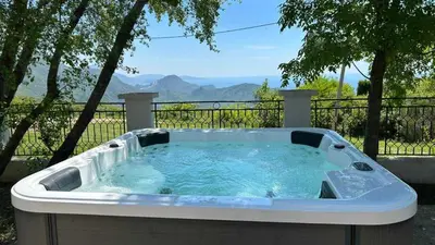 a jacuzzi tub with a view of the mountains at Holiday Home Marija in Budva
