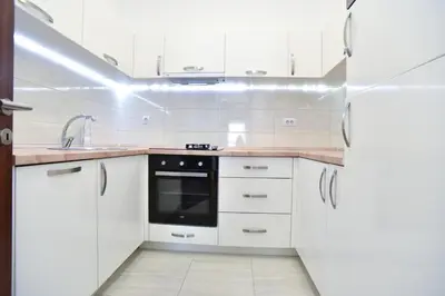 a kitchen with white cabinets and a refrigerator at BARBETA Accommodation in Budva