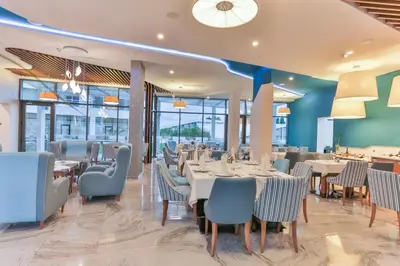 a dining room with tables and chairs and windows at BARBETA Accommodation in Budva