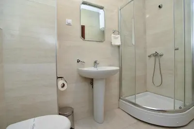 a bathroom with a shower and a sink and a toilet at BARBETA Accommodation in Budva