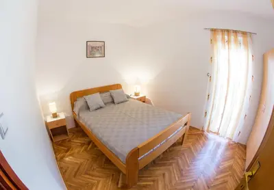 a bedroom with a bed in the middle of a room at Apartments Angela in Budva