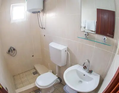 a bathroom with a white toilet and a sink at Apartments Angela in Budva
