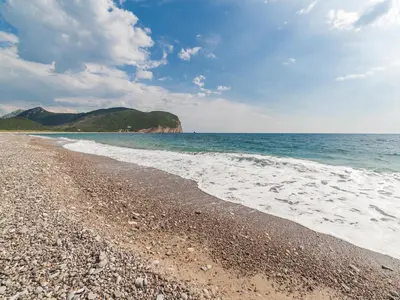 a beach with a rocky shore and the ocean at Luxury Apartments Queen in Petrovac na Moru