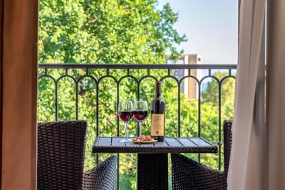 a table with two glasses of wine on a balcony at Luxury Apartments Queen in Petrovac na Moru