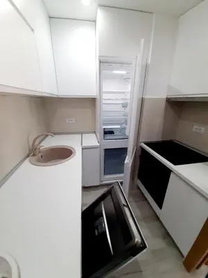 a small white kitchen with a sink and an open refrigerator at Maritimo di Cattaro****Lux Apartment with Garage in Kotor