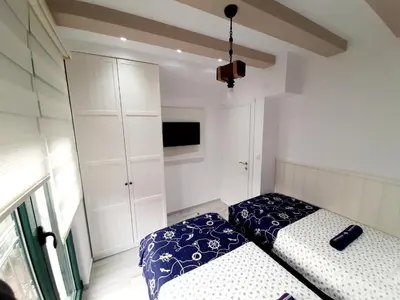 a bedroom with two beds and a cabinet at Maritimo di Cattaro****Lux Apartment with Garage in Kotor