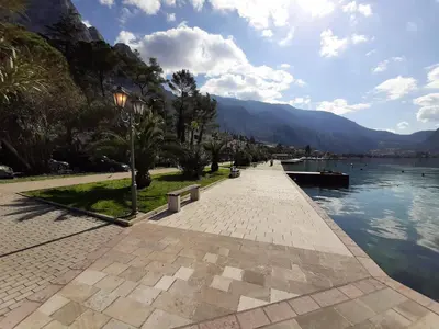 a walkway next to a body of water with mountains at Maritimo di Cattaro****Lux Apartment with Garage in Kotor