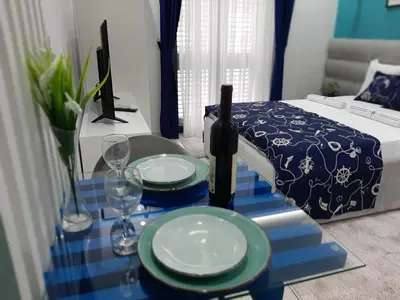 a room with a table with two plates and wine glasses at Fiore di Cattaro **** Lux Apartment with Parking in Kotor