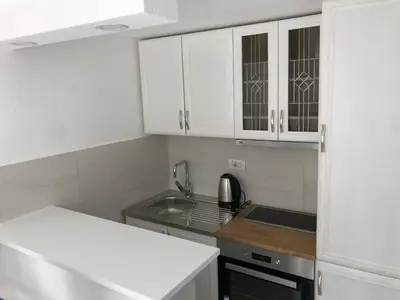 a small kitchen with white cabinets and a sink at Apartment Apollo 2 in Kotor