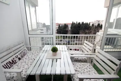 a wooden bench on a balcony with a potted plant at Apartment Terassa in Bar