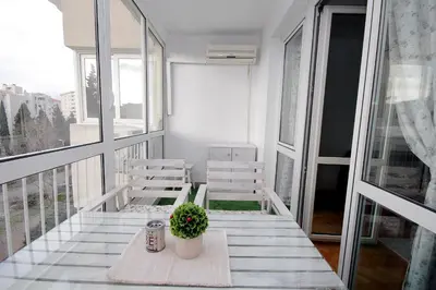 a balcony with two chairs and a table with a plant at Apartment Terassa in Bar