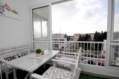 a balcony with a table and chairs and a window at Apartment Terassa in Bar