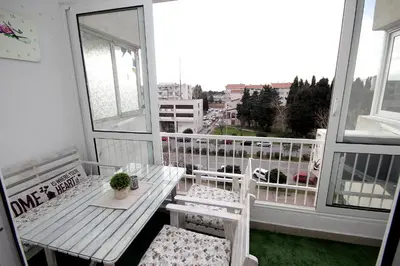a balcony with a table and two chairs and a window at Apartment Terassa in Bar