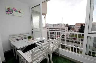 a balcony with a table and chairs and a window at Apartment Terassa in Bar