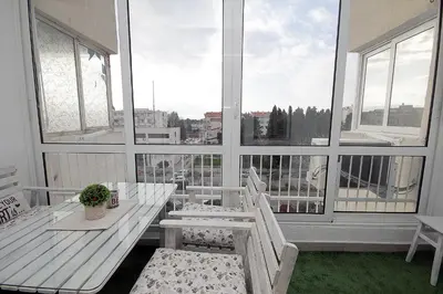 a balcony with a table and chairs and a large window at Apartment Terassa in Bar