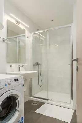 a bathroom with a shower and a washing machine at Fontana Mediteran Properties in Budva