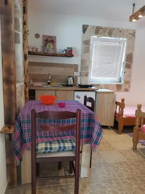 a small kitchen with a table with a tablecloth on it at Apartments Lazarević Sutomore in Sutomore