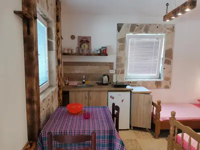 a small kitchen with a table and a sink at Apartments Lazarević Sutomore in Sutomore