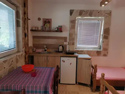a small kitchen with a table and a refrigerator at Apartments Lazarević Sutomore in Sutomore
