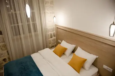 a bedroom with a bed with three yellow pillows at Palazzo Sindik in Kotor