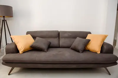 a brown couch with three pillows on it at Palazzo Sindik in Kotor